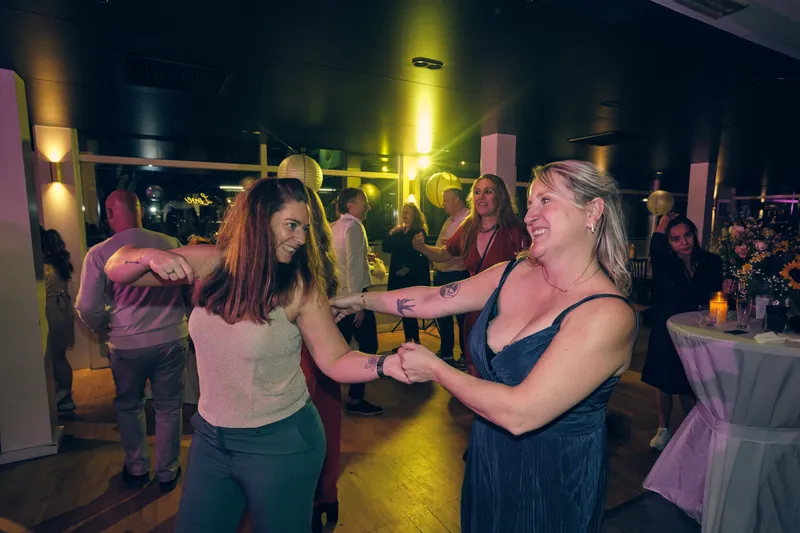 Gasten dansen in het gele licht van de dj