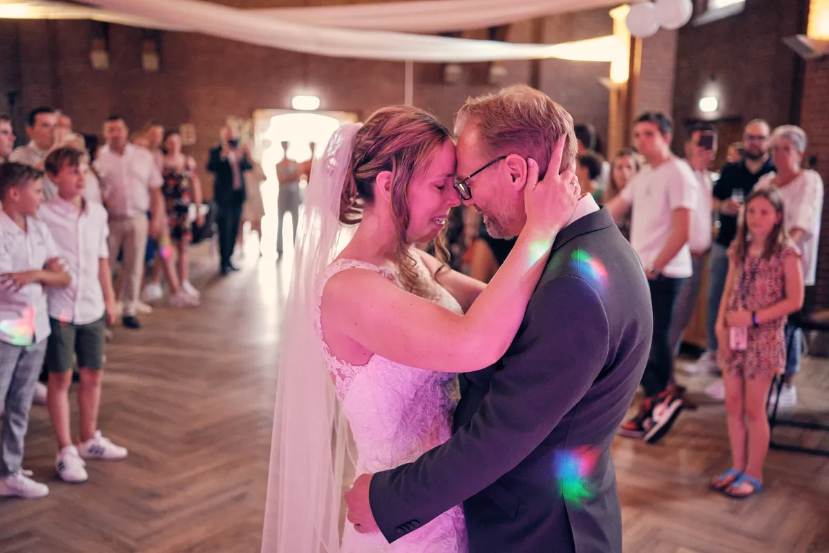Mike en Ilja kussen elkaar op de dansvloer in de kapel, tussen dansende gasten