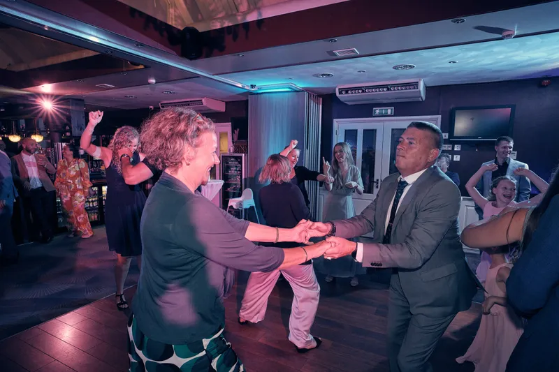 Gasten dansen in het gekleurde licht