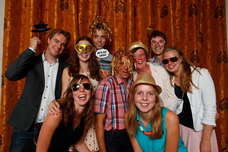 Gasten met hoeden en brillen in de fotobooth