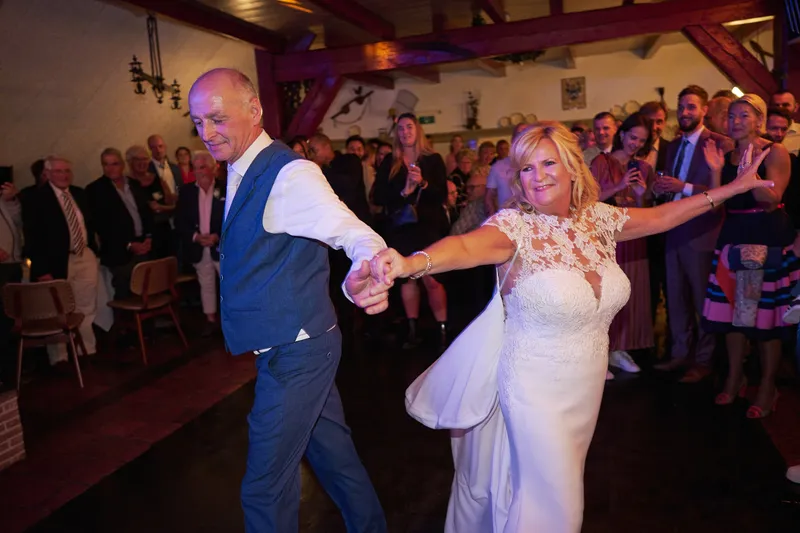 Jopie en Cees dansen hun openingsdans, de gasten staan eromheen