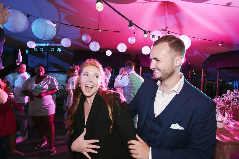 Gasten dansen in het roze licht