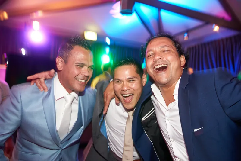 De vrienden lachen onder het gekleurde licht