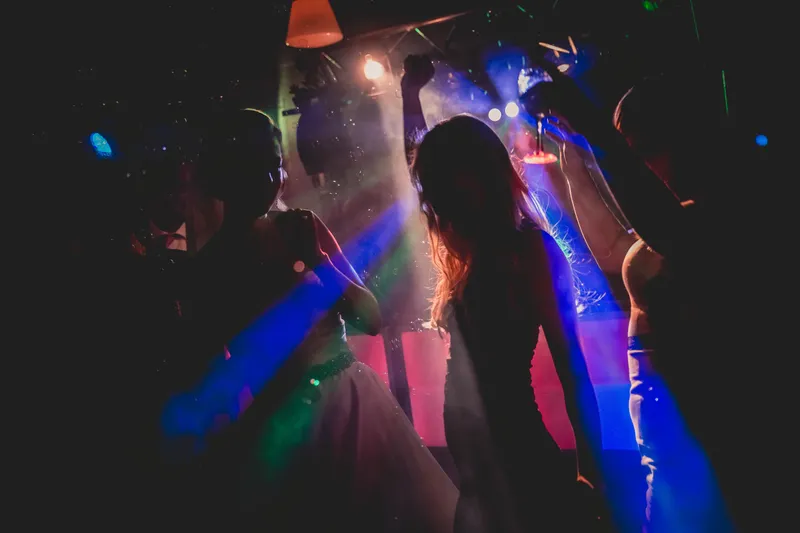 Gasten dansen in gekleurd licht