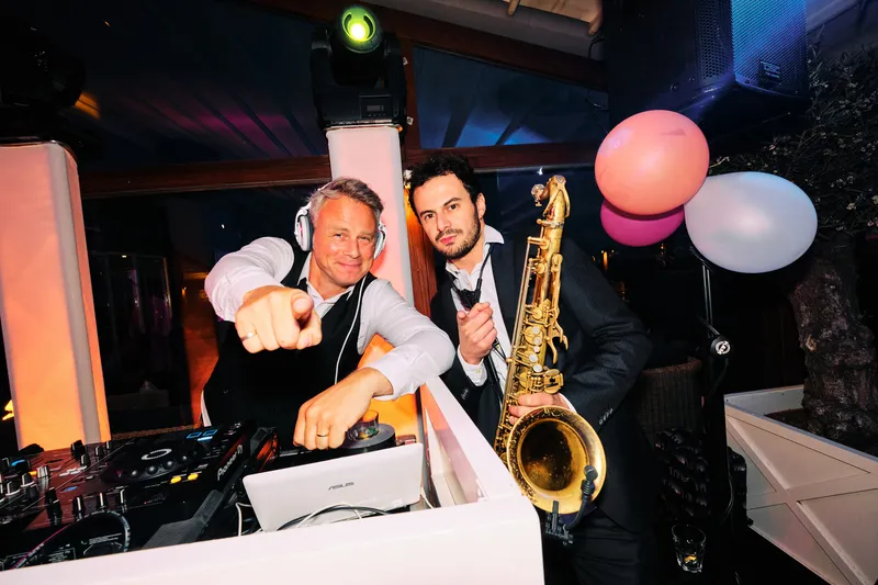 Een saxofonist speelt mee bij de dj