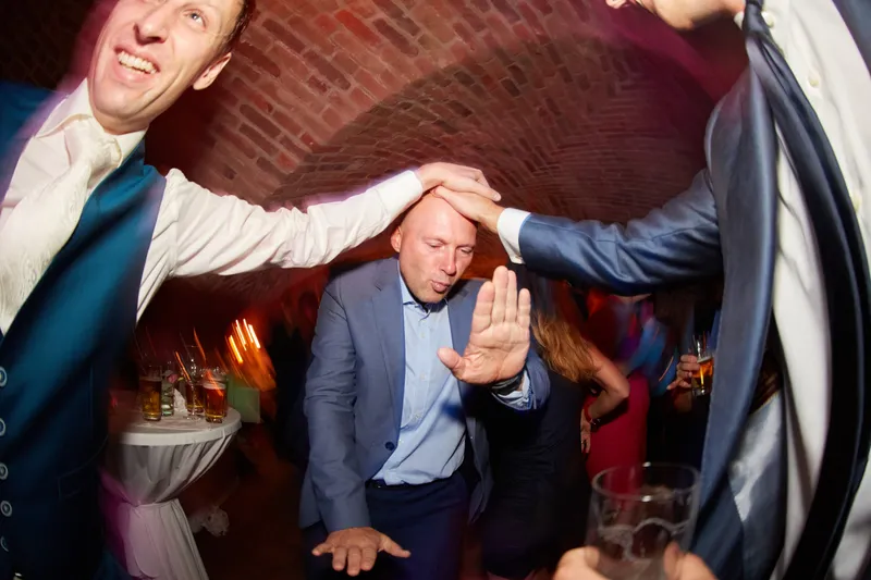 Een gast geeft een ander een tikje op het hoofd op de dansvloer