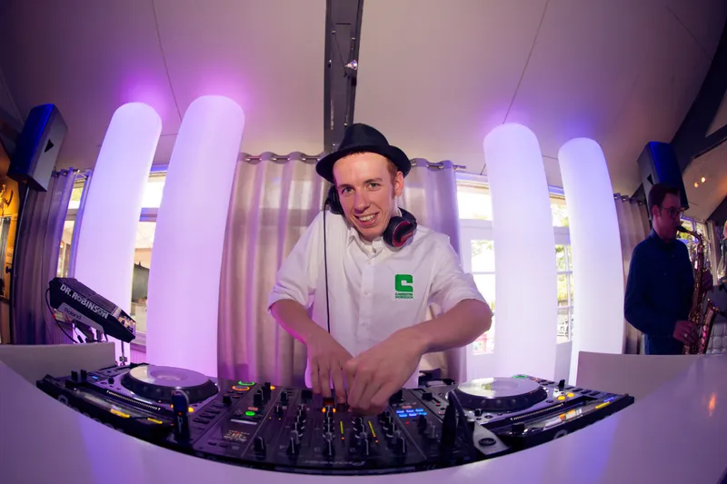 De dj achter zijn draaitafel in paars licht