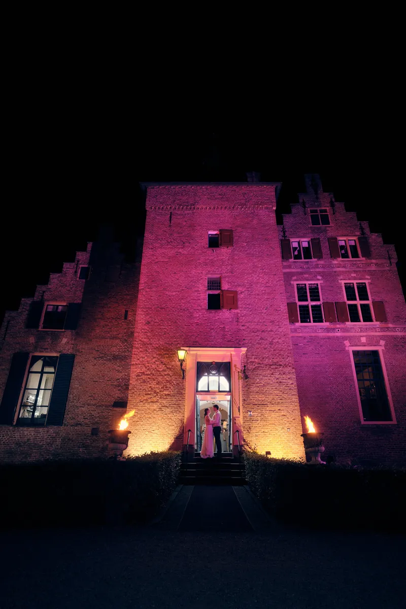 Kasteel Wijenburg ’s nachts, de gevel verlicht in roze