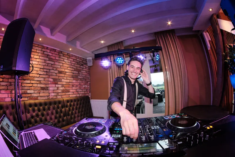 De dj voor de bakstenen muur