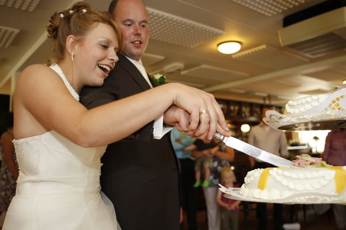 Yvonne en Robert-Jan snijden lachend de taart aan