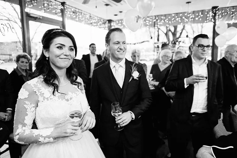 Kimberley en Mike luisteren naar een speech, met een glas in de hand