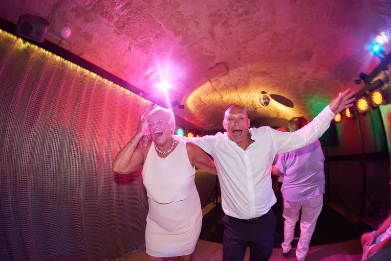 Gasten dansen in roze licht