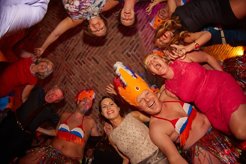 Gasten met feestattributen, van bovenaf op de dansvloer