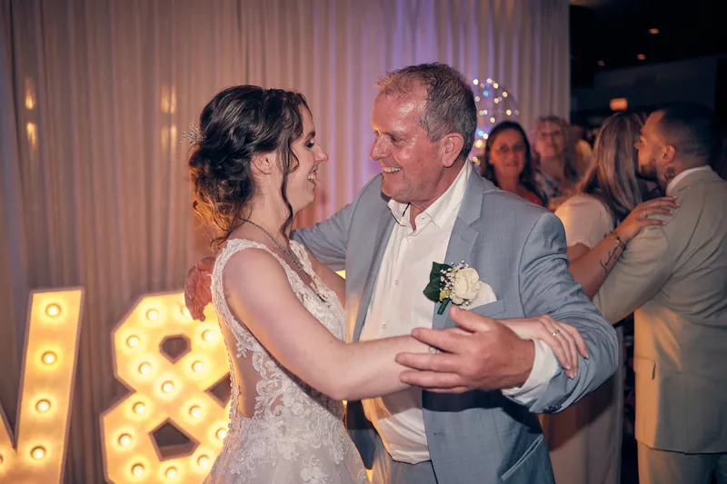 Wendy danst met een man in een lichtblauw pak bij de lichtletters