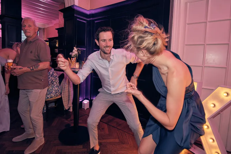 Twee gasten lachen naar de camera op het feest