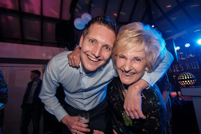 Lachen met een arm om een oudere gast