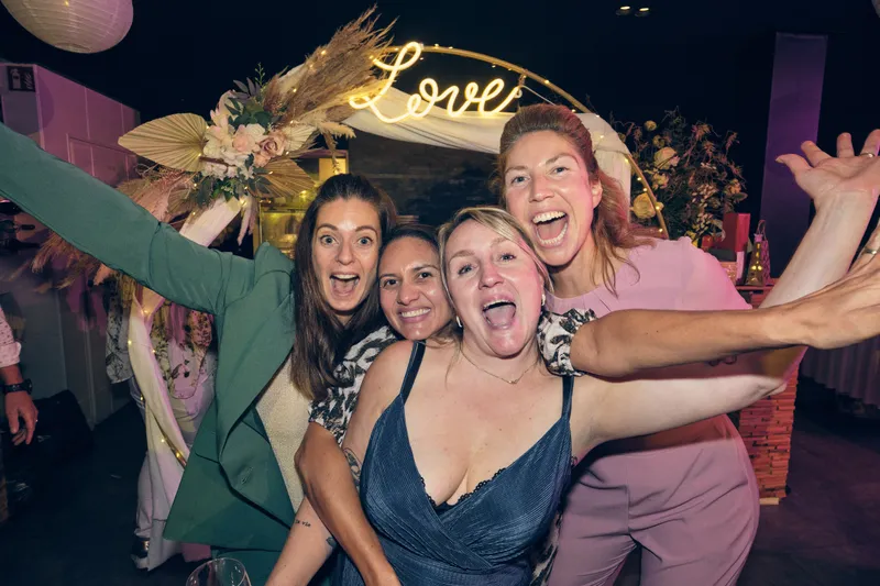 Vriendinnen juichen onder de bloemenboog