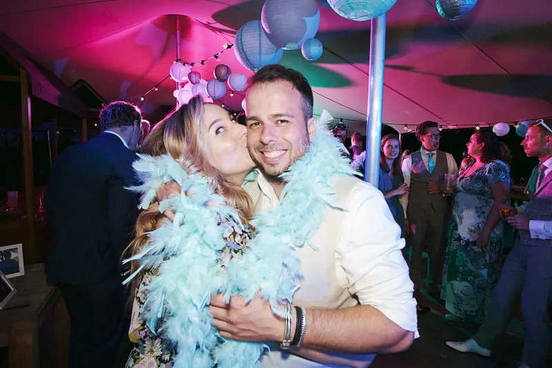 Liëla met een boa en Jeffrey omhelzen elkaar op de dansvloer