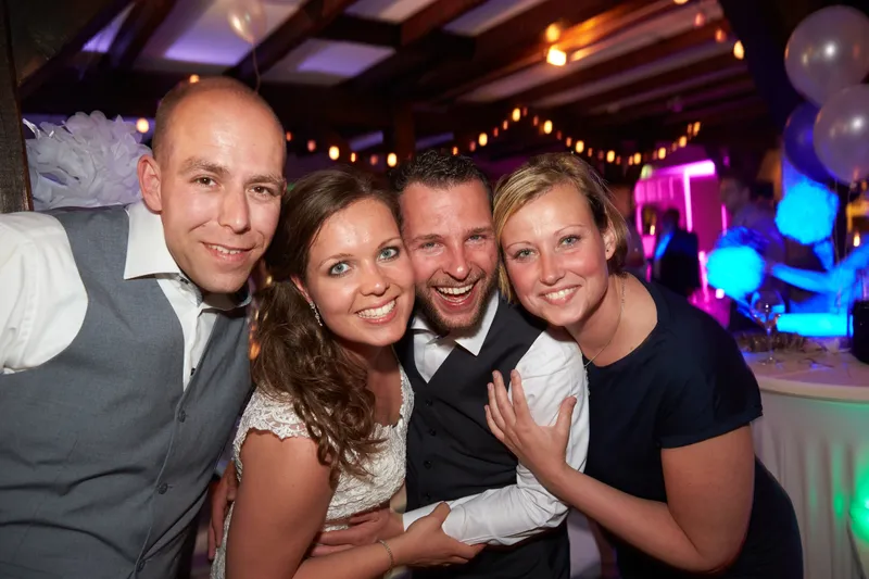 Drie gasten lachen samen in het feestlicht