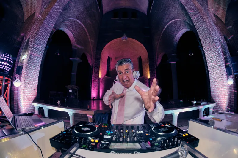 De dj achter zijn draaitafels in paars licht