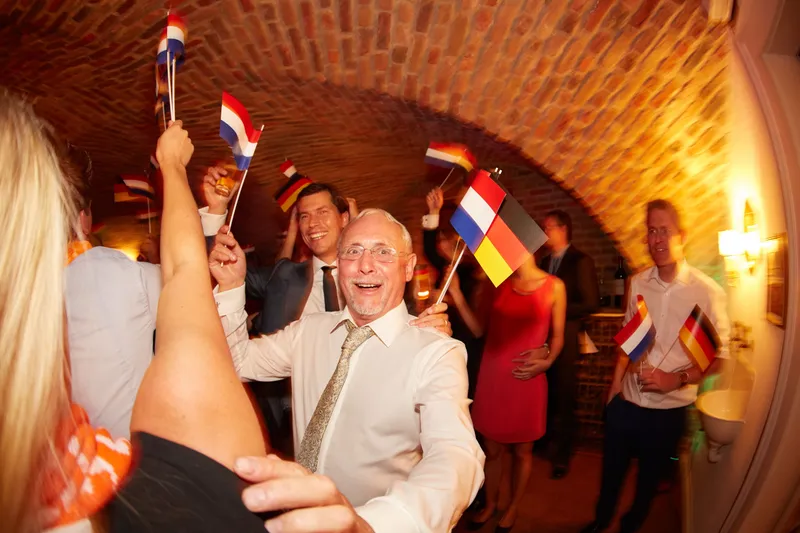 Een gast zwaait met Nederlandse en Duitse vlaggetjes