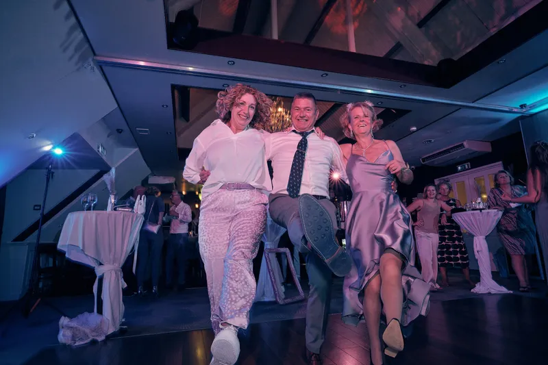 Gasten dansen in een rij over de dansvloer