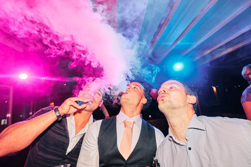 Een wolk roze rook boven de dansvloer