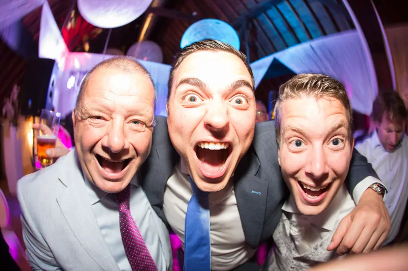 Drie gasten trekken een gek gezicht naar de camera