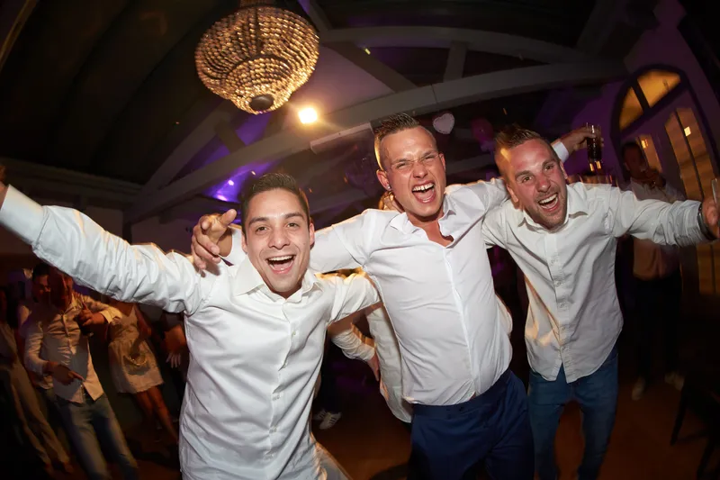 Drie vrienden met de armen om elkaar heen in paars licht