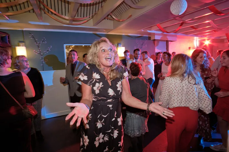 Gasten dansen met hun armen in de lucht