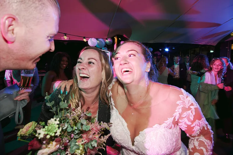 Liëla lacht met haar boeket tegen een gast aan