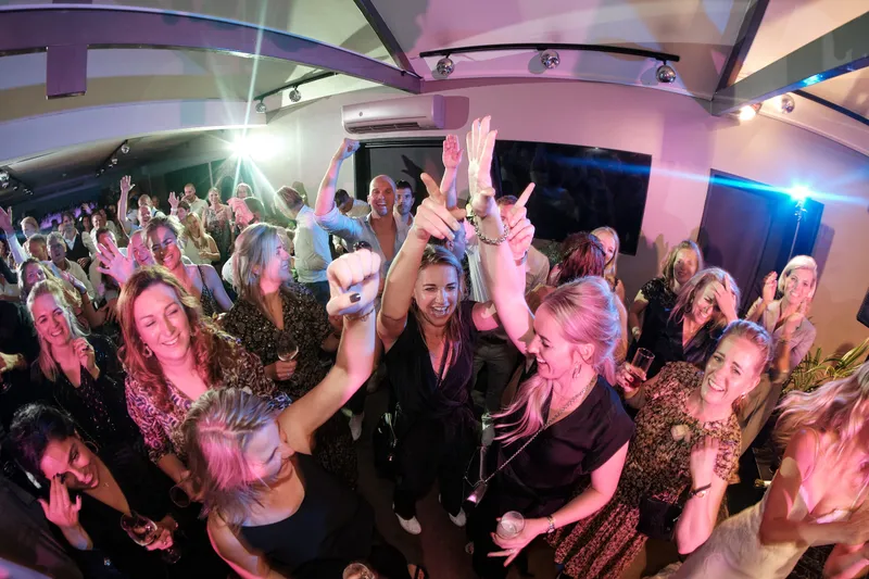 Gasten dansen met de armen omhoog