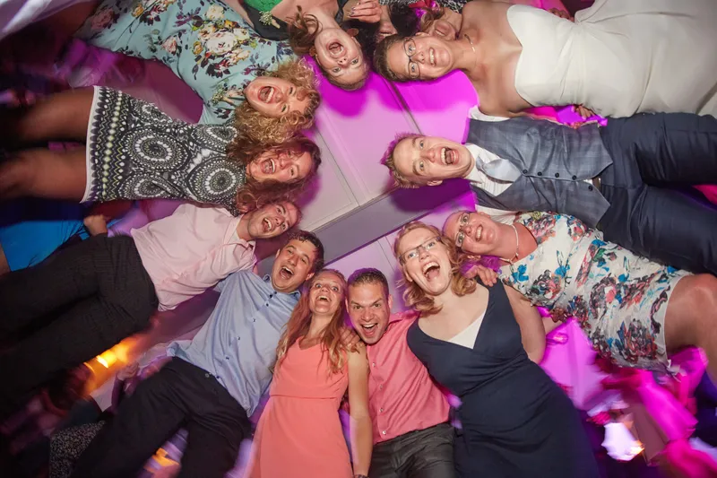 Een groep gasten van onderaf gefotografeerd op de dansvloer