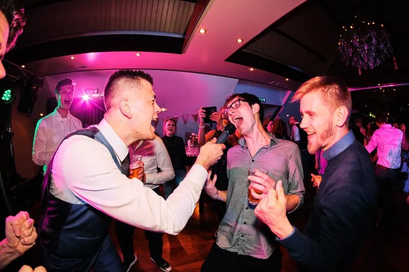 Een gast in vest danst in wit licht