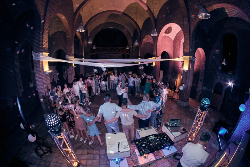 De kapel vol dansende gasten, met tule en een discobal