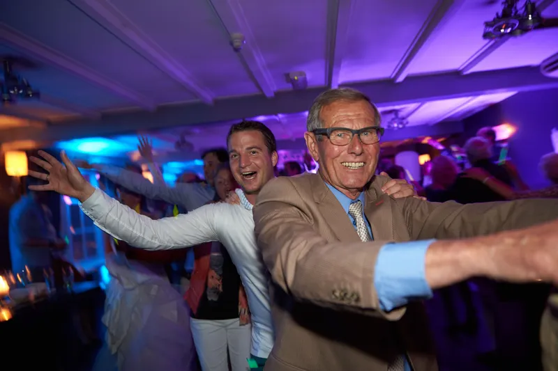 Een gast danst uitbundig in het blauwe licht