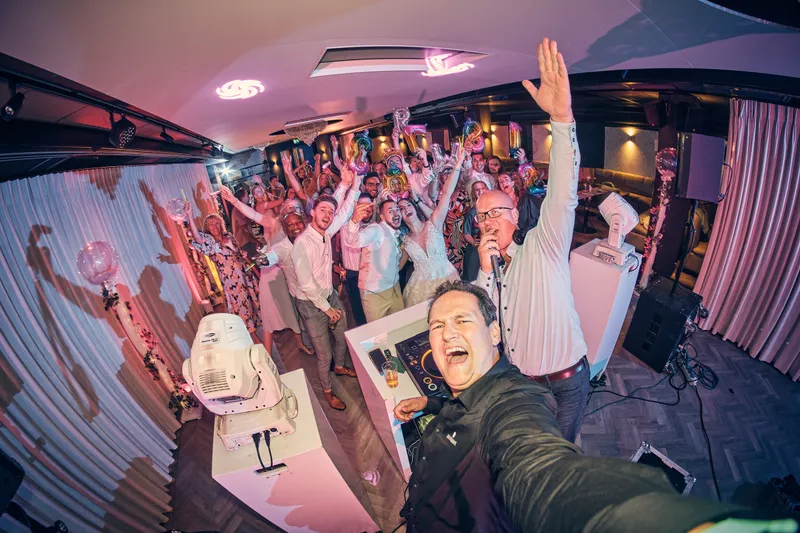 Een gast maakt een selfie met de volle dansvloer