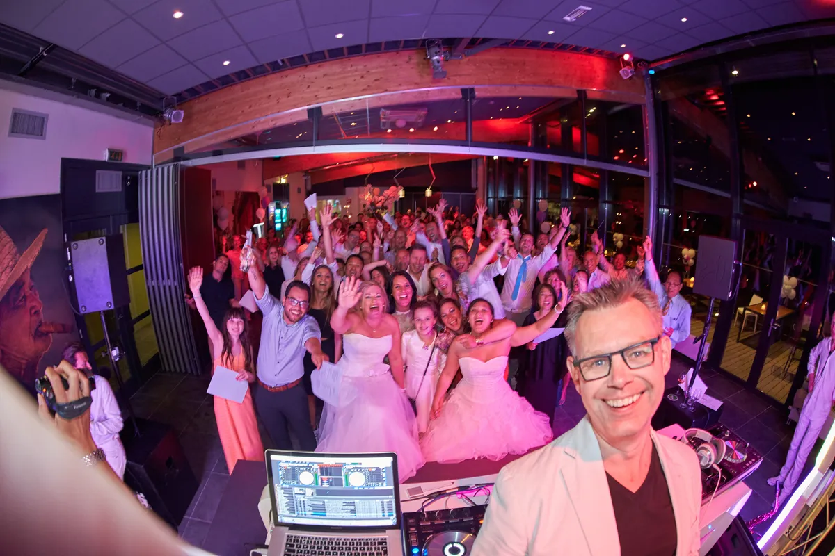 De dansvloer vol met de handen omhoog, vanaf de dj gezien