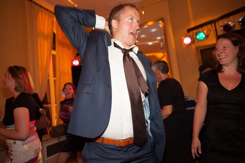 Een gast danst met zijn hand achter zijn hoofd