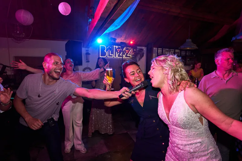 Een gast en de bruid dansen voor het neonbord