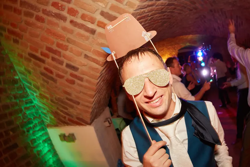 Een gast met een feestbril en een papieren hoedje