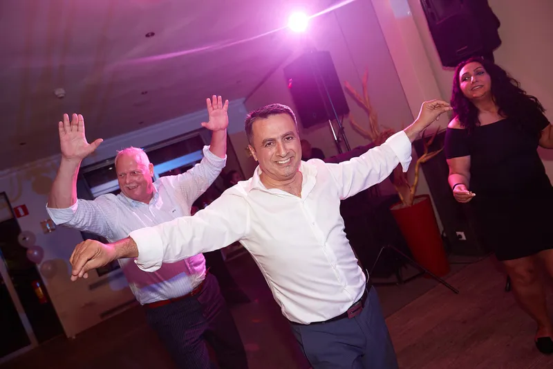 Een gast danst met zijn armen in de lucht