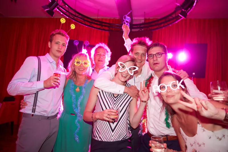 Gasten met brillen en strikjes in roze licht