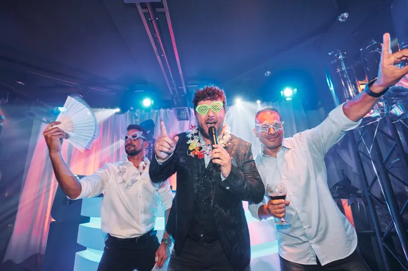 Drie mannen met een microfoon in blauw licht
