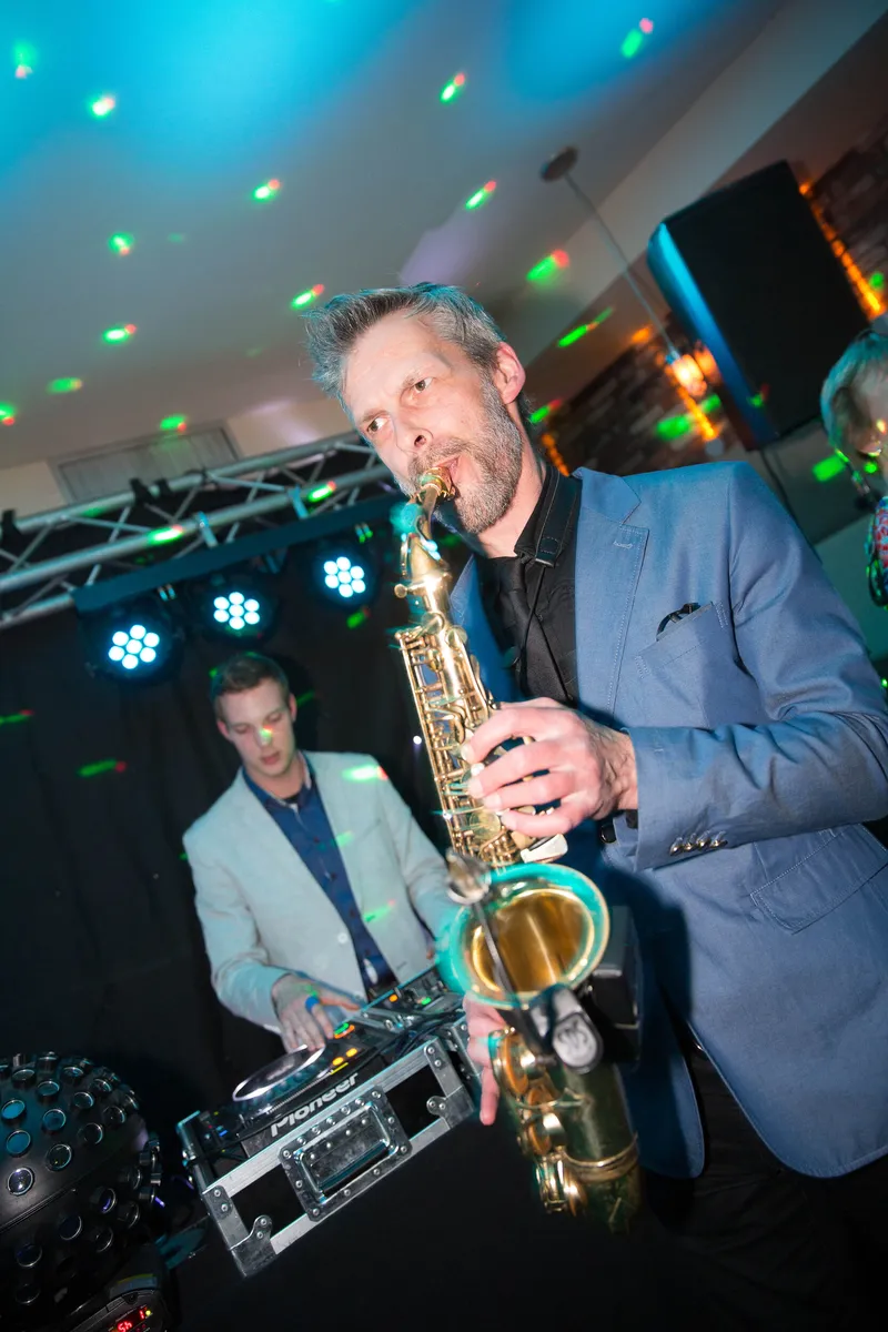 De saxofonist speelt op het feest van Anne en Hans