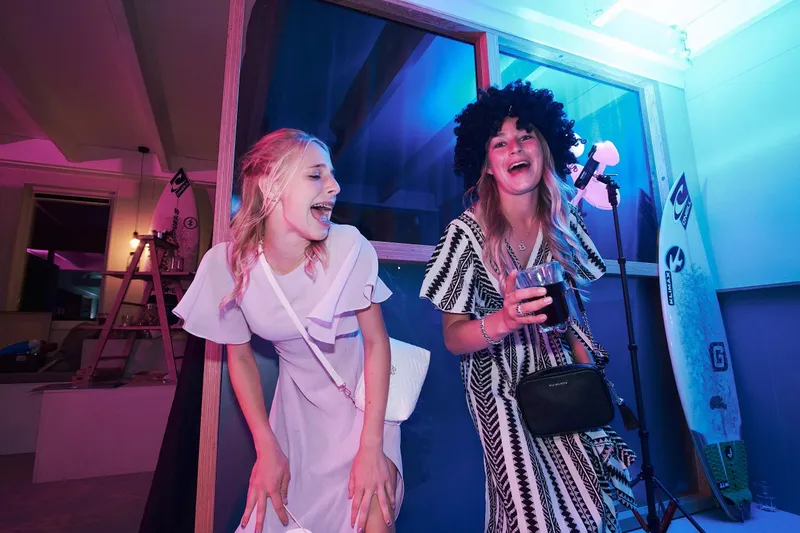 Twee vrouwen dansen in roze licht voor het podium