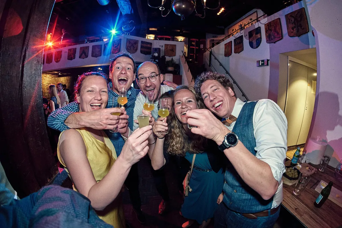 Vrienden proosten lachend naar de camera