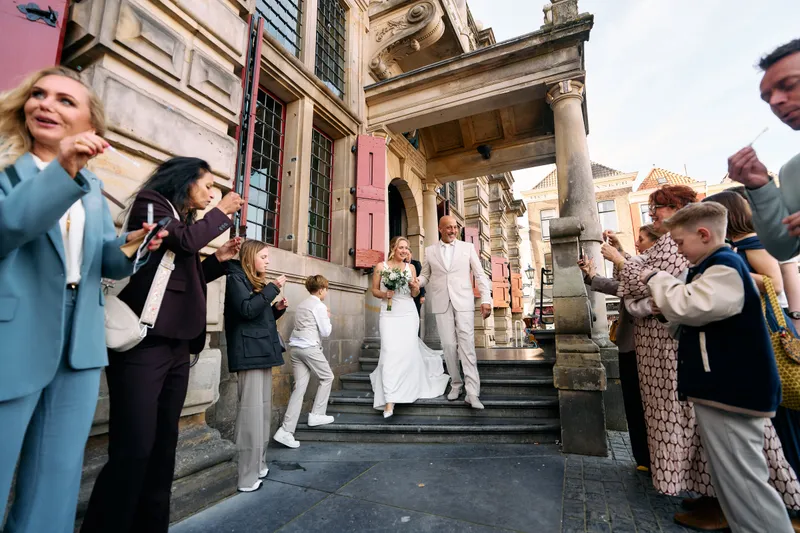 Danitsja en Brian komen de trap van het stadhuis af, de gasten staan aan weerszijden