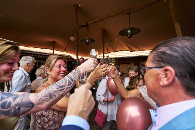 Gasten heffen hun glas in de tent