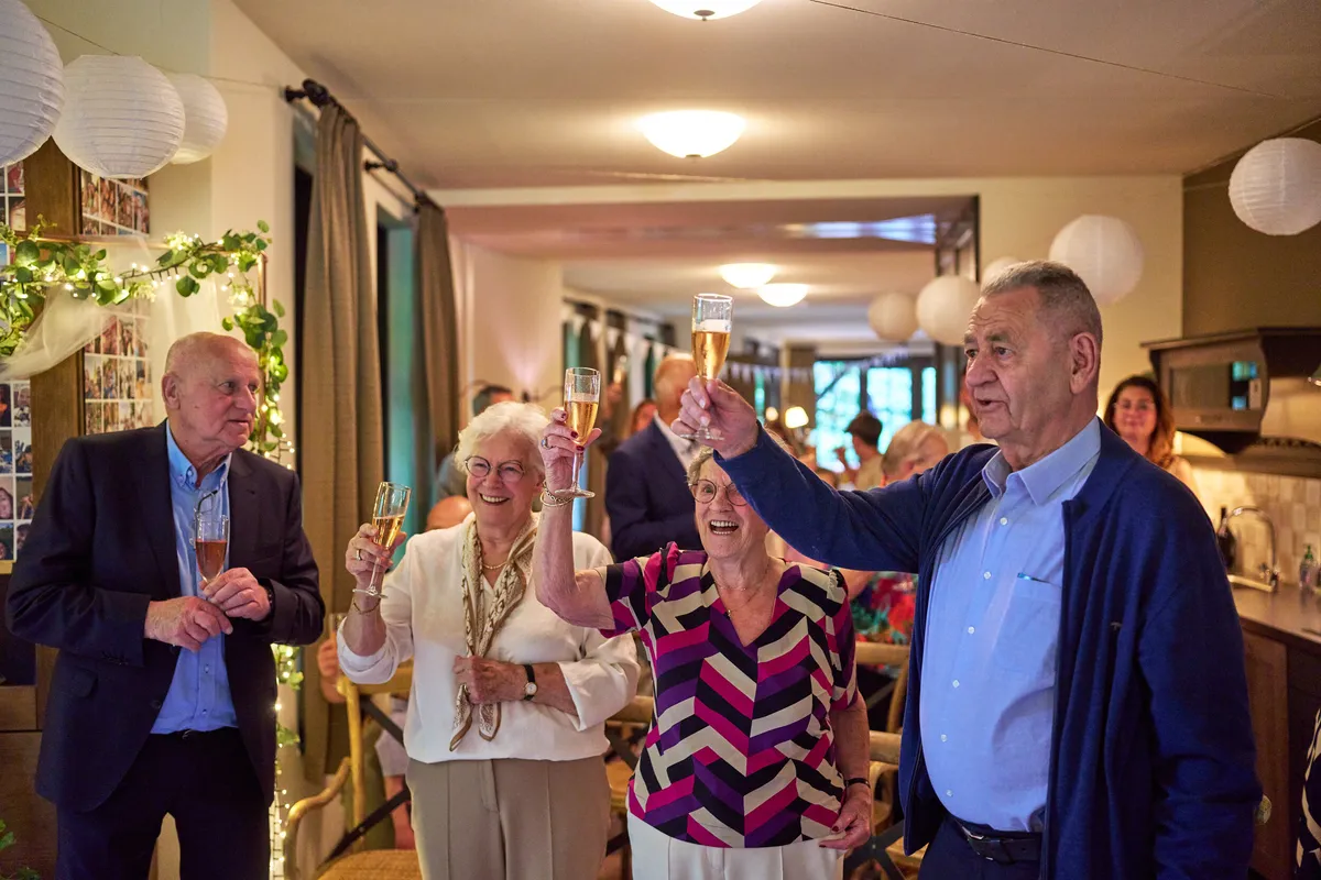 Gasten heffen het glas in de woonkamer